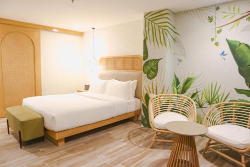 长滩岛Mandarin Nest Boracay的一间卧室配有一张床、两把椅子和一张桌子