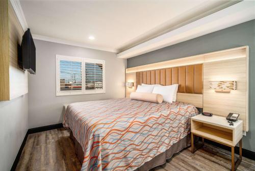 Bell加州贝尔洛杉矶旅行宾馆及套房酒店的酒店客房设有床和窗户。