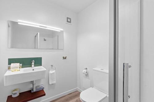 提马鲁韦纽舒适酒店的白色的浴室设有水槽和卫生间。