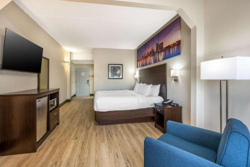 路易斯威尔Clarion Pointe Louisville East的配有一张床和一台平面电视的酒店客房