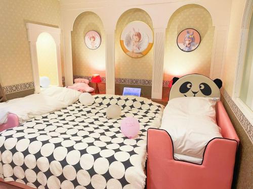 涩川市Ikaho Kids Paradise Hotel - Vacation STAY 56072v的一间卧室配有巨型熊猫床和椅子