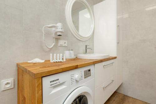 济夫努夫Dom Gościnny Amber Dziwnów - apartamenty i pokoje的一间带洗衣机和水槽的浴室