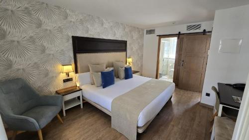 波尔托马林VISTALEGRE Hotel-Spa的一间卧室配有一张大床和一把椅子
