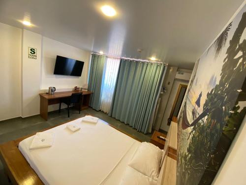 廷戈玛丽亚Hotel Rupa Rupa的客房设有1张床、1张办公桌和1台电视。