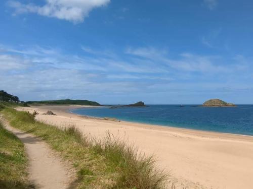 圣库隆Mobilhome tout confort, proche Saint-Malo, à 50 m de la plage et du GR34的阳光明媚的日子,海边的沙滩