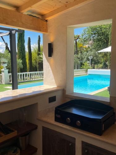 RoussasLe Mas de l'Alliance - 12 p - Air Cond - private Pool - near Grignan的厨房设有游泳池,透过窗户可以看到