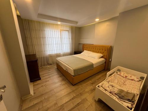 MidyatXANTHOS APART HOTEL Midyat Merkezde的一间带一张床和一张婴儿床的小卧室
