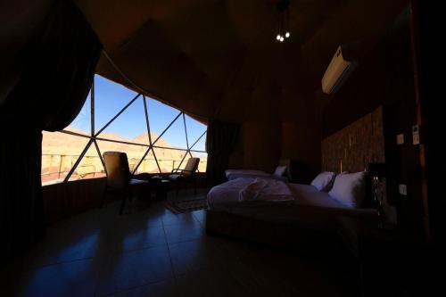 瓦迪拉姆Adel rum camp bubbles的一间卧室设有一张床和一个大窗户