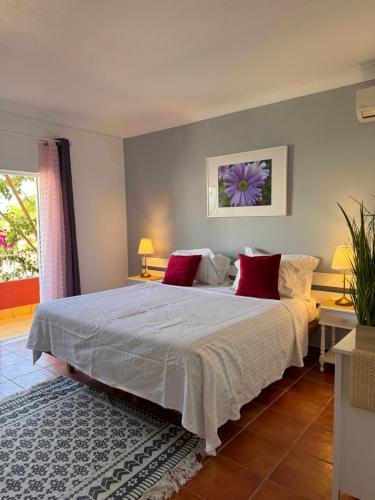 拉戈斯Vila Graciosa - Tranquility Oasis的卧室配有带红色枕头的大型白色床