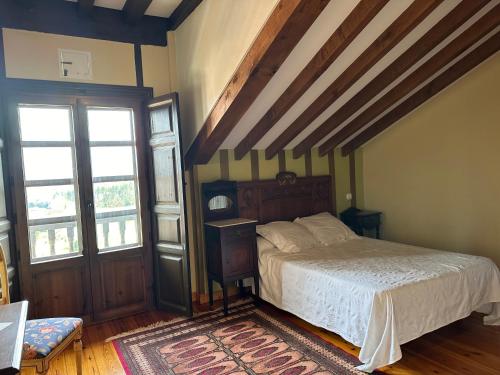 CerrazoHotel Palacio La Casona de Cerrazo的一间带一张床的卧室,位于带木制天花板的房间内