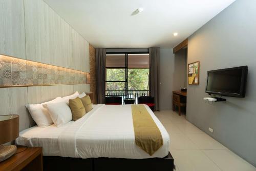 素可泰Sukhothai Treasure Resort & Spa- SHA Plus Certified的酒店客房,配有床和电视