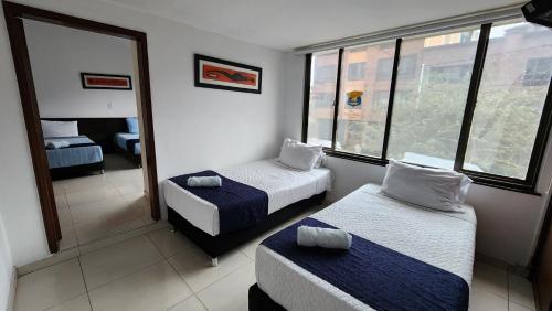 波哥大AG精品酒店的酒店客房设有两张床和窗户。