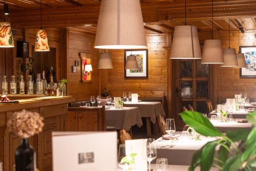 佩尔森贝格Pension Hinterleithner的餐厅设有桌子、白色桌布和灯