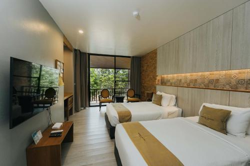 素可泰Sukhothai Treasure Resort & Spa- SHA Plus Certified的酒店客房设有两张床和电视。
