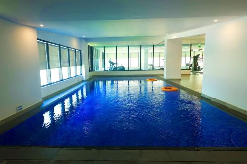 麦纳麦Noor Amwaj Hotel & Apartment的大楼内的一个蓝色海水游泳池