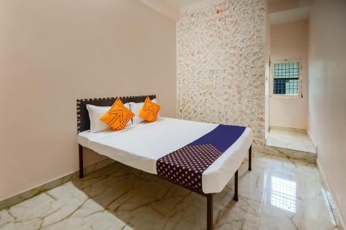 瓜廖尔SPOT ON 66974 Hotel shri gurukripa的一间卧室配有带橙色和蓝色枕头的床