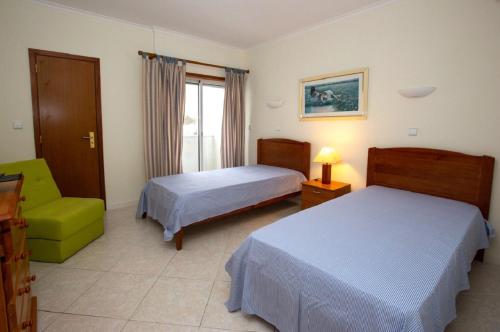 阿尔布费拉Onda Verde的酒店客房,设有两张床和一把绿色椅子