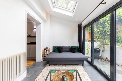 伦敦Cosy and Modern Battersea Home的带沙发和窗户的客厅