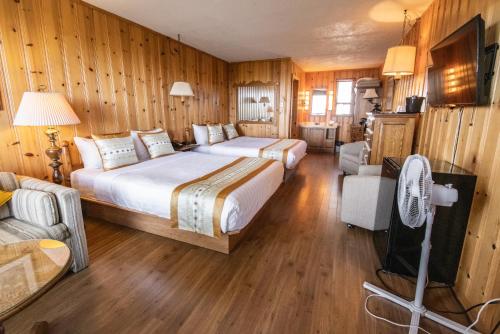 库德尔岛拉罗什普鲁乎斯酒店的配有木墙和木地板的客房中的两张床