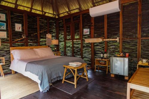 圣玛尔塔Solea Villa Tropical的卧室配有一张床铺,位于带木墙的房间内