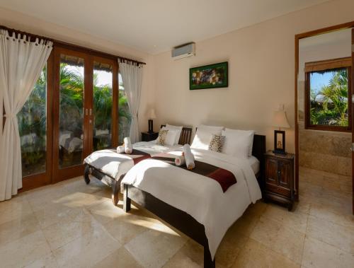 金巴兰巴拉根海滩别墅酒店的一间卧室设有两张床和窗户。