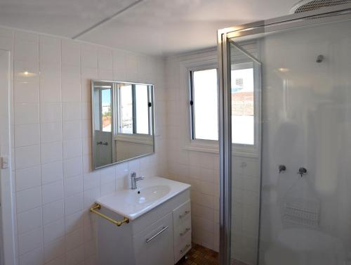 卡尔古利卡尔古利宫殿酒店的白色的浴室设有水槽和淋浴。