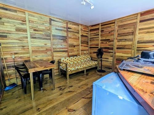 乌维塔Arboura Eco Cabins的木墙客房内的一张桌子和一张长凳