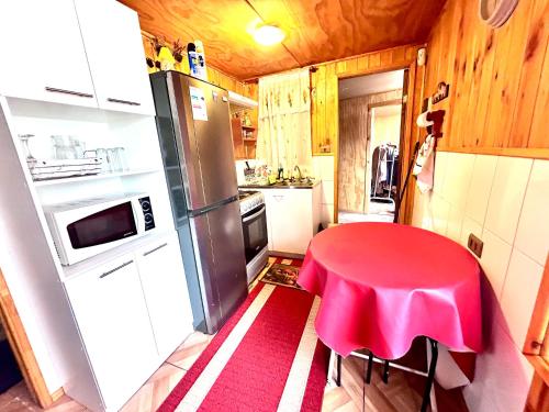 奥索尔诺Cabañas Emma的一间带红色桌子和冰箱的小厨房