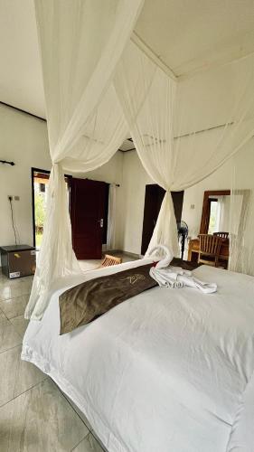 希德门Papahan Bali的卧室配有带窗帘的大型白色床