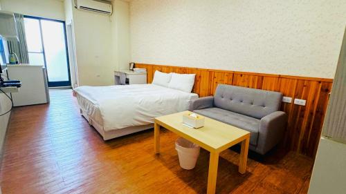 台南Didi House的一间卧室配有一张床、一张沙发和一张桌子
