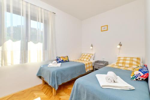 木洛希尼Argo Apartmani的一间卧室设有两张床和窗户。