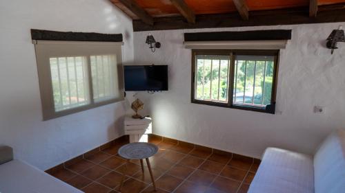 塔里法Rural Tarifa Villa María的一间带电视和2扇窗户的客厅