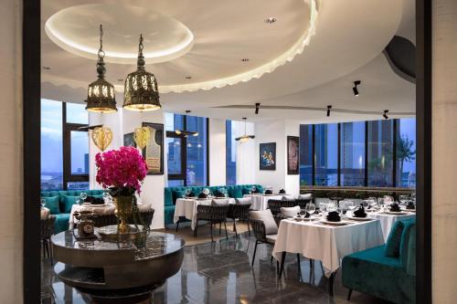 金边Chaiya Palace Hotel的用餐室设有桌椅和窗户。