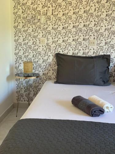 斯塔菲罗斯Skopelos Inn的一张带黑色枕头和墙壁的床