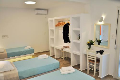 米克诺斯城Alexandra Mykonos Port的小房间设有两张床和一张书桌