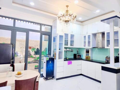 莲三Apec Sunsea Condotel Phu Yen的一间大厨房,配有白色的橱柜和吊灯