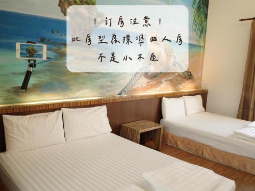 小琉球岛小杉丘民宿的墙上画画的房间里设有两张床