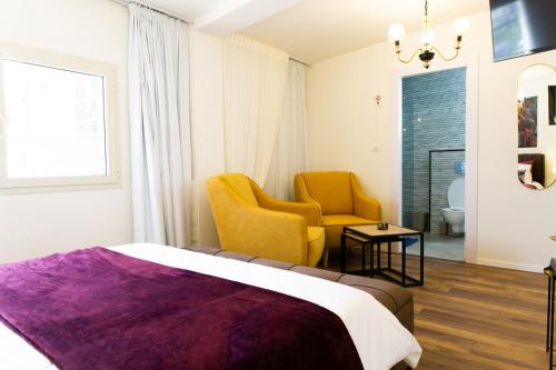 特拉维夫沙尔玛公寓的配有一张床和一把椅子的酒店客房