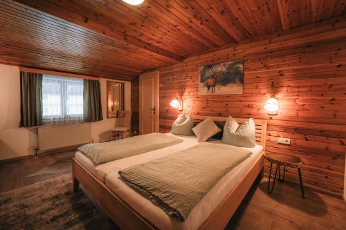 大格洛克纳山道旁富施Pension Andrea的木制客房内的一间卧室配有一张大床