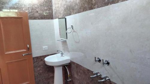 达兰萨拉Happy home stay, Dharamshala的一间带水槽和镜子的浴室