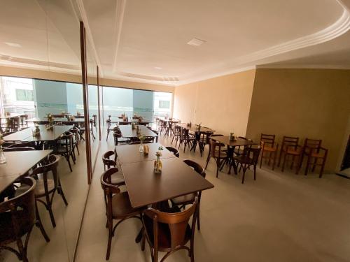 泰谢拉迪弗雷塔斯Hotel Cantinho Verde的一间在房间内配有桌椅的餐厅