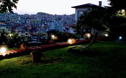 桑丹斯基Guest House Sofia的公园,晚上在草地上设有长凳