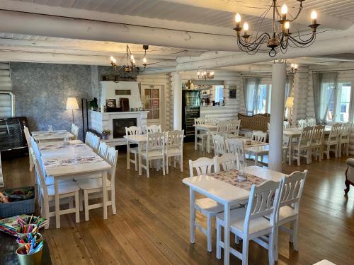 PangaKliff Butiik Majutus & Restoran的用餐室配有白色的桌子和白色的椅子