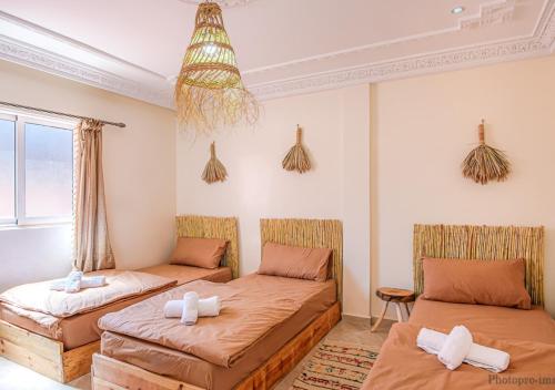 塔姆拉赫特乌兹达尔Surf Bliss tamraght的一间客房配有两张床和一张沙发