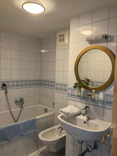 巴特格莱兴贝格Louisenvilla的一间带水槽、浴缸和镜子的浴室