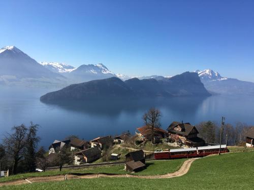 菲茨瑙Cozy House above Lake Lucerne in car-free Vitznau Mittlerschwanden at Mount Rigi railway的一条穿越山丘上村庄的火车