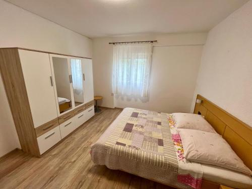 巴尔巴特纳拉布Apartmani Krunić的一间卧室配有一张床、梳妆台和镜子