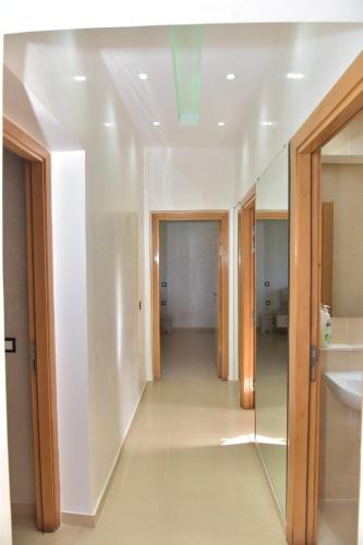 非斯Golf Royal appartement的走廊上的浴室设有水槽和镜子
