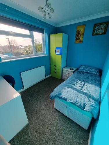 LonghamBeautiful guest house的蓝色卧室,配有床和黄色橱柜