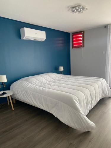 MeyriéMaison 3 chambres, 3 SdB, terrasse, piscine, spa的一间卧室设有一张蓝色墙壁的大床